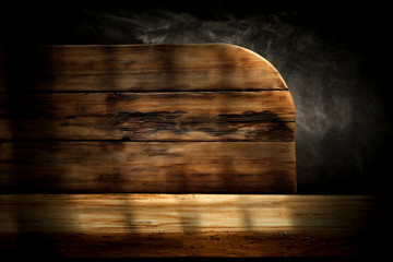 Wooden desk of free space and dark mood background.
