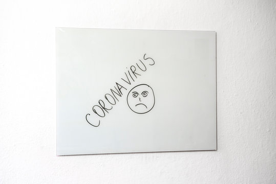 Sad face and Coronavirus on white board