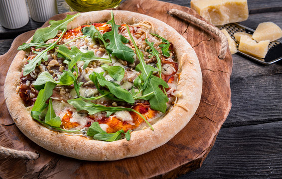 Homemade pizza with arugula, nuts and cheese
