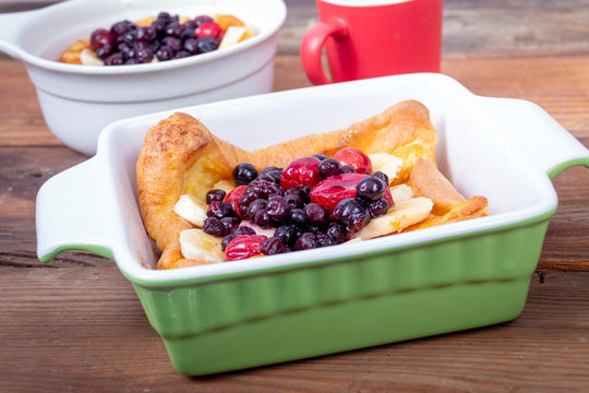dutch German pancake topped with bluberries berries fruit and banana