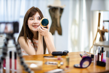 Portrait of young asian woman review giveaway gift prosduct fan following channel, recording video make up lipstic cosmetic at home. Beauty blogger present beauty cosmetics.