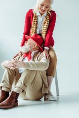 Smiling elderly woman hugging stylish man on white background