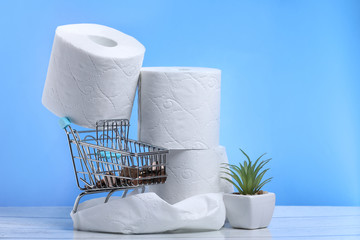 Blue shopping cart with money and toilet paper on a blue background
