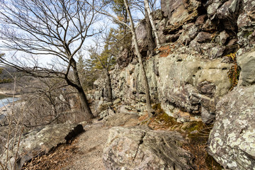 Hiking trail in early spring above a lake along the rock cliffs of a state park central in Wisconsin