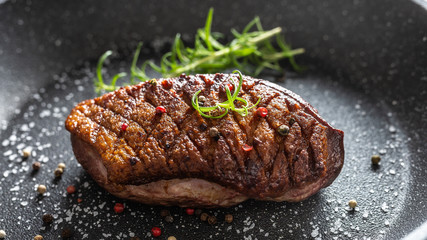 Duck breast roasted in ceramic pan with salt spices and rosemary
