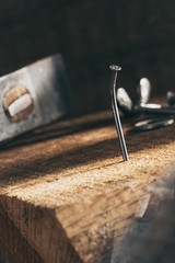 Nagel im Holzbrett mit Hammer und Schrauben