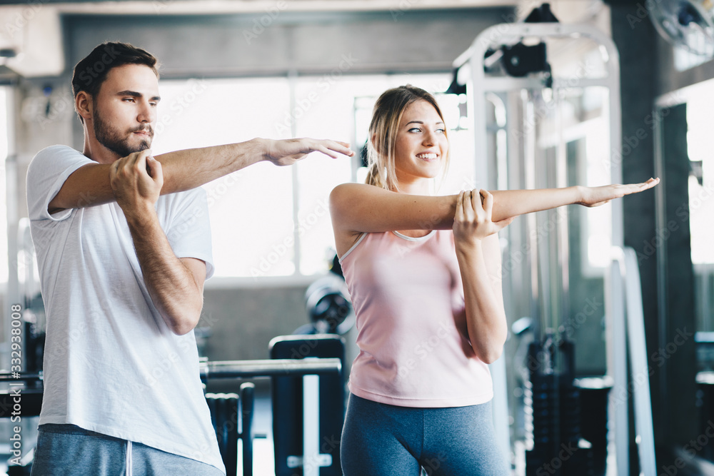 Wall mural sport couple stretching muscle before sport activity in fitness gym club