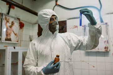 Scientist doctor biologist in hazmat suit and protective respiratory mask working in laboratory...