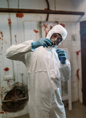 Scientist doctor biologist in hazmat suit and protective respiratory mask working in laboratory with test tubes searching vaccine against Coronavirus COVID-19
