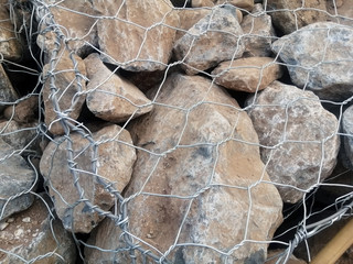 Limestone in wire mesh for construction.