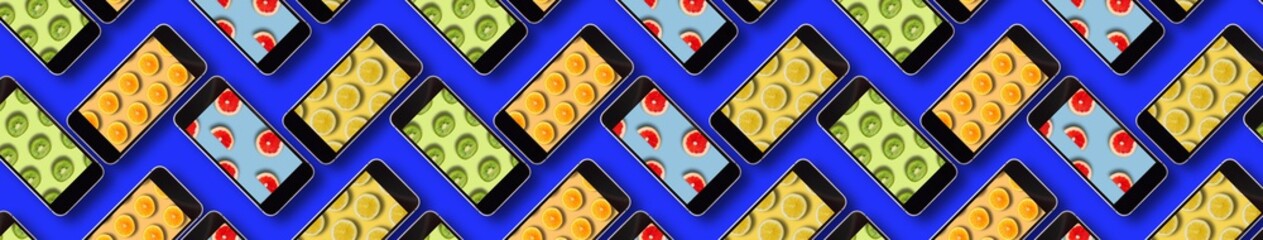 pattern with cell phones with the image of fruit on the screen on a blue background