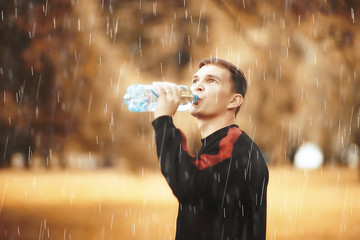 man drinking water bottle park