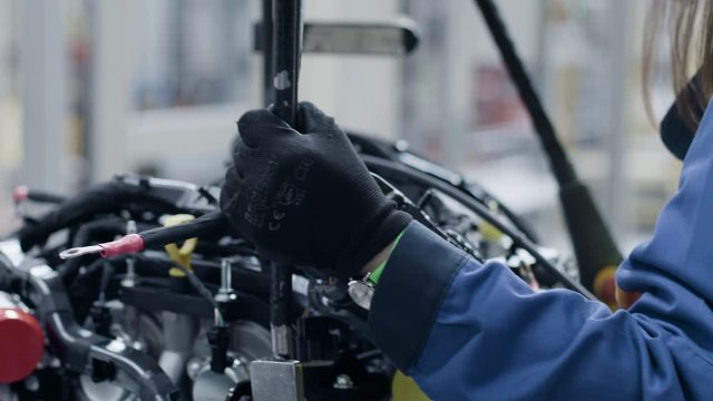 Factory worker inside an automotive manufacturing plant. Working on a car engine