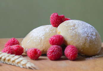 cookies and fresh raspberries on a light green background