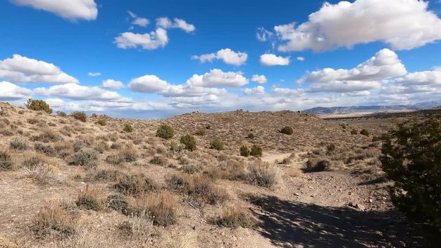 Riding desert riding rocky trail 4K POV. Off road trail riding in 4x4 all terrain vehicle for sport and recreation. Dry arid landscape. Grass lands, rocky terrain and sand dunes. 