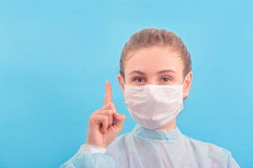 Pretty young nurse in lab coat and surgical mask showed sign think about safe and be responsible