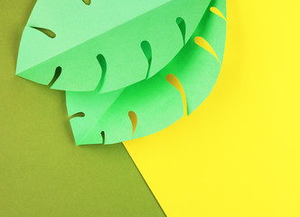 green leaves of tropical plants made of paper. yellow-green summer exotic background