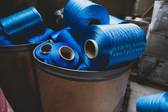 Beh&auml;lter mit Resten blauer Garnrollen f&uuml;r die Textilindustrie