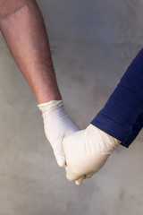 Couple wearing protective gloves holding hands