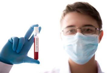 Test tube in male hand close up, doctor in medical mask holding vial with red liquid. Concept blood...