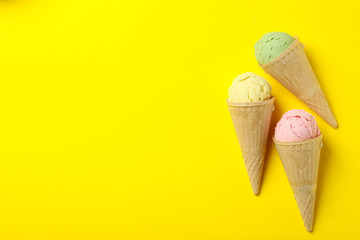 Ice cream in waffle on yellow background, space for text
