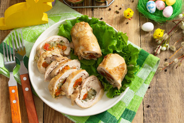 Festive appetizer. Chicken meatloaf with dried apricots, mozzarella and herbs on a festive Easter table. Copy space.