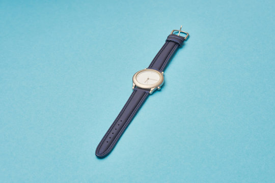 new watch with a leather strap with arrows on the dial time 6:15.