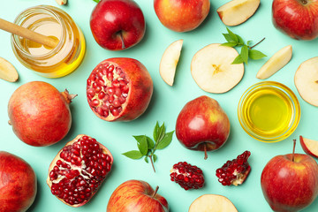 Flat lay with apple, honey and pomegranate on mint background