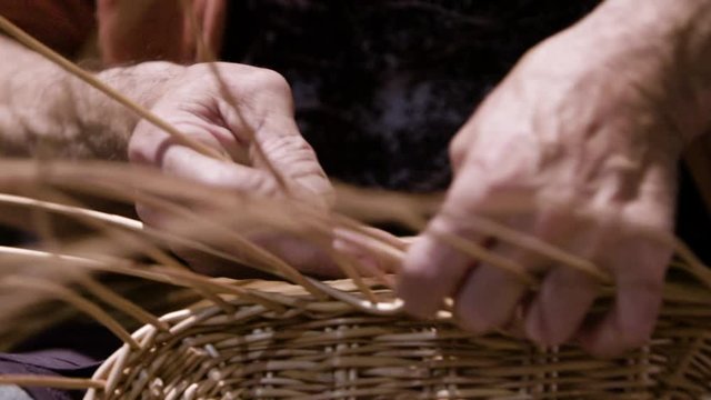 Local artisan hand weaving a wicker basket. Hands close up