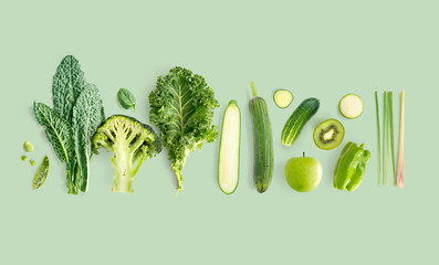 Creative layout made of kale, broccoli, green beans, zucchini, cucumber, apple, kiwi, lemongrass ...