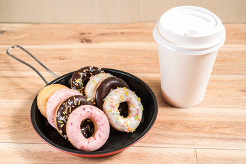 Donuts and drink and iron frying panon wood table background top view copy space pattern
