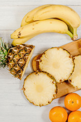 Ripe pineapple cut on slices on wooden background