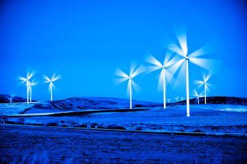 Windmill Wind Turbine Spinning in Wind at Sunset or Sunrise