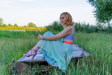 A young girl sits hugging her knees.