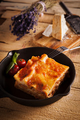 mediterranean italian kitchen Lasagna Bolognese in a pan on wooden rustic table
