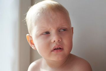 Little blond boy with a funny expression.