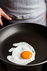 Man Holding Fried Egg On The Pan