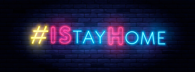 I Stay home hashtag in neon style. Coronavirus pandemic protection and prevention effort. Social activity message. Self-isolation and quarantine. To stay at home brightly illuminated neon sign on wall
