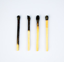 Four burned matches arranged in a row showing the stages of a match burnt