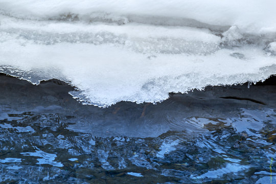 cracked ice on river in spring time. snow and ice melt in spring turn into blue water