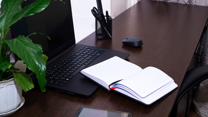 Comfortable workplace with laptop and notepad in the home office. Distance learning online. Remote...