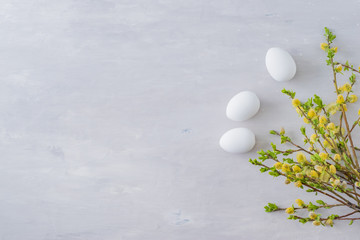 Flat lay easter composition with a willow branch and eggs on a gray background