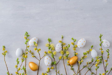 Flat lay easter composition with a willow branch and eggs on a gray background