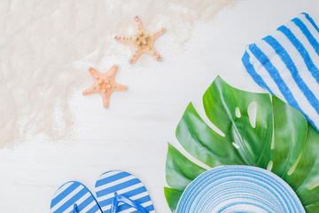 Flat lay composition with a summer hat and flip flops on a light background