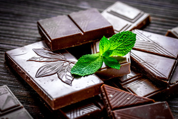 chopped chocolate pieces with mint for dessert wooden desk background