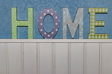 Sign saying 'Home' on a blue and white wall