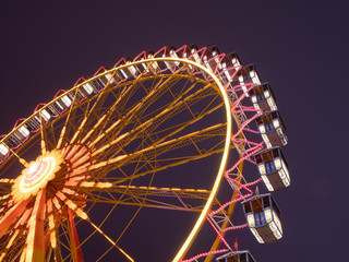Hamburg, Germany November 11, 2019. Bottom up view of the illuminated ferries wheel on the Hamburger DOM amusement park in the evening.