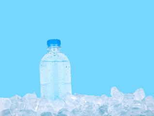 Plastic bottle of drinking water on ice over blue