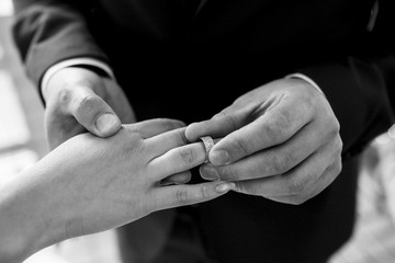 groom puts bride on wedding ring