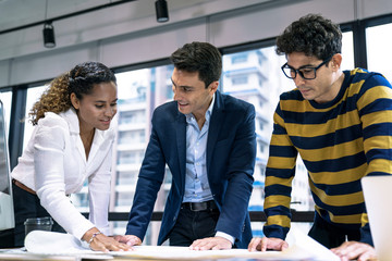 A group of young business people working together while sitting at their desks in the office, Business meeting.